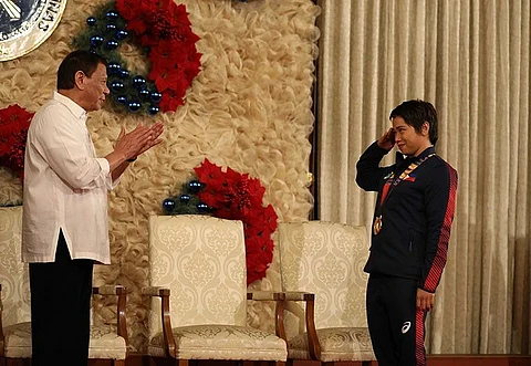 MANILA. President Rodrigo Roa Duterte gets a salute from weightlifting gold medalist Hidilyn Diaz during the awarding of the Order of Lapu-Lapu Rank of Kamagi to the 2019 Southeast Asian Games medalists at the MalacaƱan Palace on December 18, 2019. (Presidential photo)