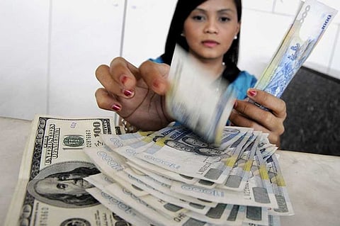 STEADY. A bank teller counts Philippine peso for a client selling US dollars. The Cebu Bankers Club is optimistic that money sent home by overseas Filipino workers will not be severely affected by the global tensions abroad, such as the Covid-19 global outbreak. (AP photo)