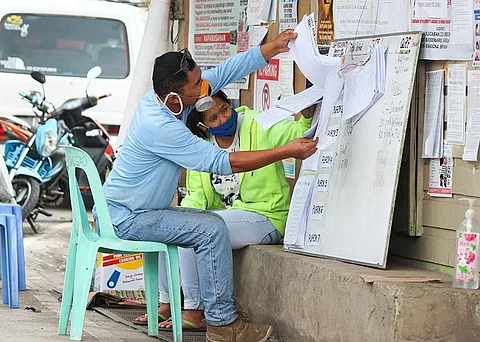 BAGUIO. A resident of Barangay Camp 7 looks at the list of names of approved Social Amelioration Program (SAP) applicants posted outside in their barangay hall. Baguio City is practicing maximum transparency in the government's cash incentive program amid the pandemic. (Photo by Jean Nicole Cortes)