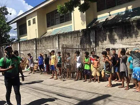 TISA TROUBLE. Members of Task Force Kasaligan (in green shirts) line up quarantine violators, adults and minors, in Barangay Tisa, Cebu City on Thursday afternoon, Oct. 1, 2020. The violators include eight children, who played games inside an internet cafe without masks and they also failed to observe social distancing. / Contributed, Cebu City Police Office