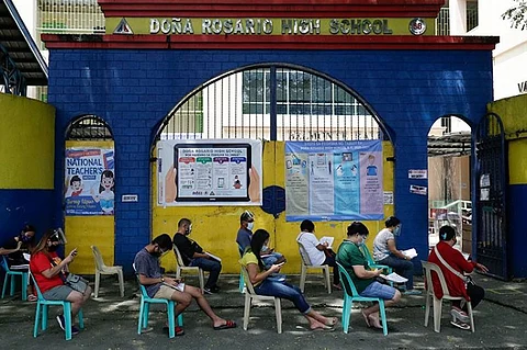MANILA. People wearing masks and face shields wait for their turn to pick up student electronic tablets as online classes are scheduled to start next week in the Dona Rosario High School in Quezon City, Philippines, Thursday, October 1, 2020. (AP)
