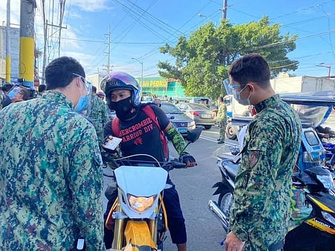 MANILA. Police check the ID of a motorcycle rider on the first day of a new lockdown to tame transmission of Covid-19 in the NCR, Bulacam Cavite, Laguna and Rizal. (Third Anne Peralta-Malonzo)