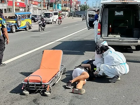 FIRST AID. Paramedics provide first aid to a rider who was injured in an accident in Barangay Dau, Mabalacat City Sunday morning, August 22, 2021. (Photo by Reynaldo G. Navales)