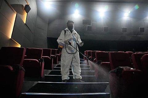 A worker in protective suit sanitizes a moviehouse as they prepare to reopen at the Eastwood mall in Quezon City, Philippines as government eases restrictions after a decline in Coronavirus cases in the country on Thursday, October 14, 2021. (AP)