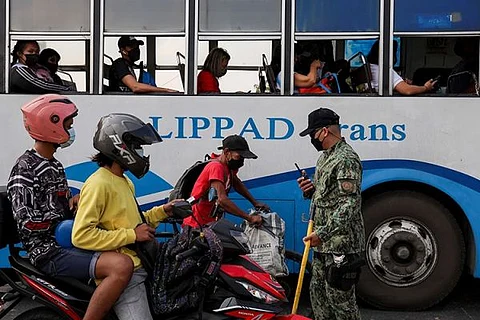 MANILA. A police officer checks documents at a checkpoint as the government enforced another round of strict health restrictions to control the rise of Covid-19 cases at the outskirts of Quezon City in Manila, Philippines on Monday, January 10, 2022. (AP)