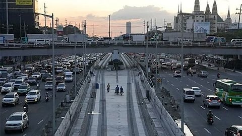 MANILA. In this file photo, workers walk along a construction site of the MRT (Metro Rail Transit) while traffic builds up in Quezon City, Philippines as restrictions continue to ease due to a decline in Covid-19 cases in the country on Friday, December 3, 2021.