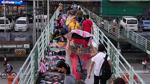 MANILA. A man, wearing a mask to protect against the coronavirus, carries rugs in Quezon City, Philippines as restrictions continue to ease due to a decline in Covid-19 cases in the country on December 3, 2021.