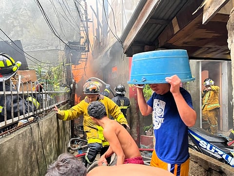 NAGTIBANGAY: Ang mga lumolupyo sa Sityo Sto. Niño Laguna, Brgy. Duljo Fatima, siyudad sa Sugbo nagtinabangay sa pagpalong sa kayo sa sunog kagahapon sa hapon, Agusto 4,2022. / Benjie B. Talisic