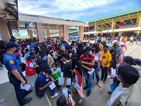 ZAMBOANGA. At least 29 people were injured in a stampede Saturday, August 20, 2022 at the entrance of a local public school when huge number of people gathered to avail of the Department of Social Welfare and Development's (DSWD) educational assistance. A photo handout shows a policeman stands watch while applicants fill up the form of their application to avail DSWD's educational assistance program. (SunStar Zamboanga)
