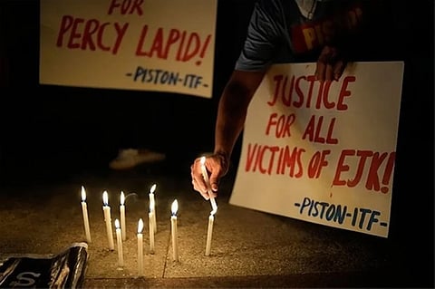 MANILA. Activists hold a candle beside slogans as they condemn the killing of Filipino journalist Percival Mabasa during a rally in Quezon City, Philippines on October 4, 2022.