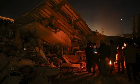 TURKEY. Rescue workers stand by a collapsed building in Adiyaman, southern Turkey, Thursday, Feb. 9, 2023. Thousands who lost their homes in a catastrophic earthquake huddled around campfires and clamored for food and water in the bitter cold, three days after the temblor and series of aftershocks hit Turkey and Syria. ( AP Photo/Emrah Gurel)