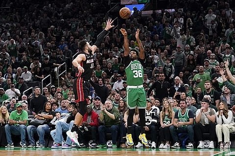 Boston Celtics guard Marcus Smart, right, shoots as Miami Heat guard Max Strus defends during the first half in Game 5 of the NBA basketball Eastern Conference finals series Thursday, May 25, 2023, in Boston. (AP Photo/Charles Krupa )