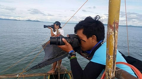 Photographers on the lookout for the shy Irrawaddy dolphin.