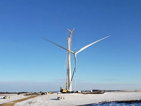 The 2 MW hybrid solar-wind system being set up by Juhl Energy using GE Renewable Energy’s technology in Minnesota will have solar essentially providing summer peak energy and wind providing winter peak energy, as per GE. Pictured is GE 2.0-116 rotor being lifted in place. (Photo Credit: GE)