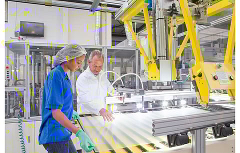 As demand for solar modules soars in Europe, India’s BRL sees its acquisition of Interfloat to position itself as a local supplier of solar glass with a low carbon footprint. Pictured are an engineer and technical working on coating glass for use in production of solar panels. (Illustrative Photo; Photo Credit: Juice Flair/Shutterstock.com)