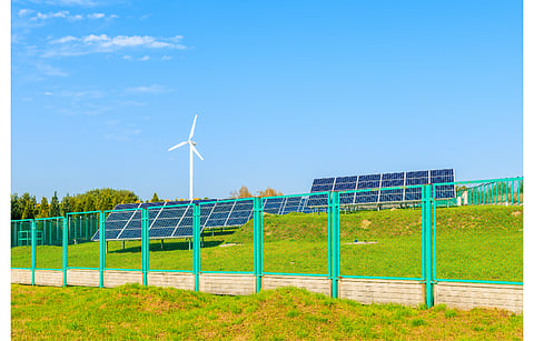 Poland sees the new Energia dla wsi scheme as enabling additional income source for farmers and bringing down their energy costs, in the wake of energy crisis Europe is currently facing. Pictured are solar panels with wind turbine in the background in Poland. (Illustrative Photo; Photo Credit: Pawel Kazmierczak/Shutterstock.com)