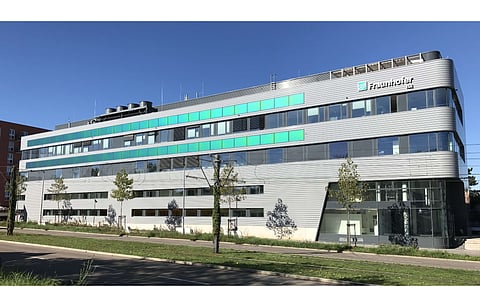 Pictured is the façade-integrated PV system with green MorphoColor® glass at the Center for Highly Efficient Solar Cells at Fraunhofer ISE. (Photo Credit: Fraunhofer ISE)