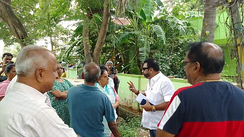 A DMK leader who came to occupy a land belonging to the Corporation in Coimbatore fled after being surrounded by the public