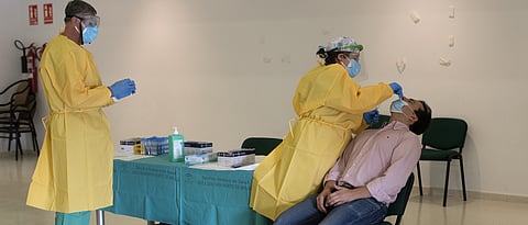 A healthcare worker takes a swab sample during a mass testing for COVID-19