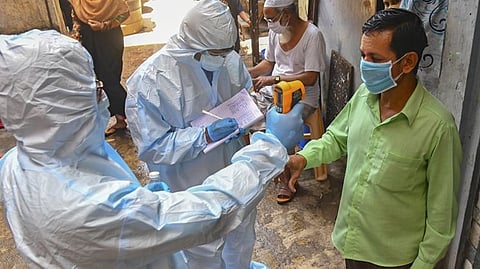 Health workers checking the temperature during the screening for COVID-19 (file photo)