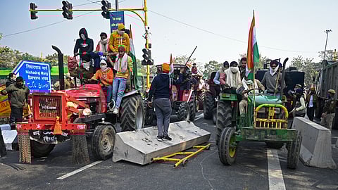 Farmers on tractors remove police barricades during a rally as they continue to protest against the central government's recent agricultural reforms in New Delhi