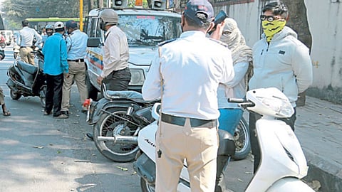 Traffic police imposing fine on those travelling on bikes with rear-view mirrors