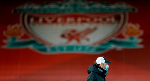 Liverpool's German manager Jurgen Klopp, wearing a face mask or covering due to the COVID-19 pandemic, walks on the pitch ahead of the English Premier League football match between Liverpool and Brighton and Hove Albion at Anfield in Liverpool,