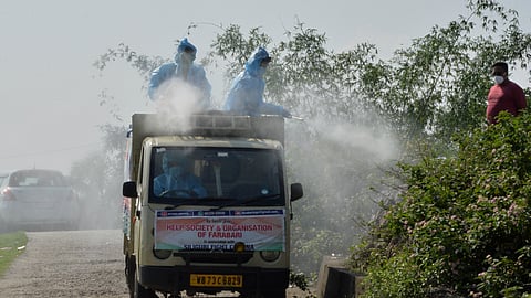 Members of NGO spray disinfectant in the area of a crematorium being used only to cremate the COVID-19 victims on the outskirts of Siliguri, West Bengal
