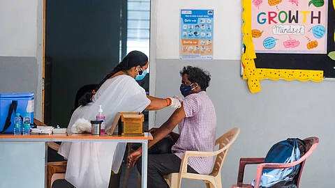 A health worker inoculates a man with a dose of the Covishield vaccine against COVID-19 during a vaccination drive in Hyderabad