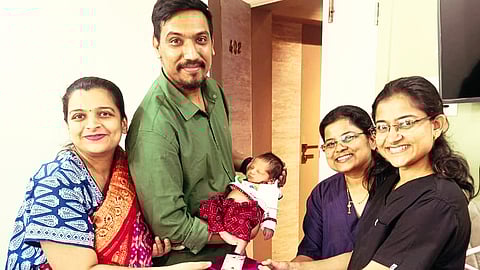 Anjali with her husband and new born