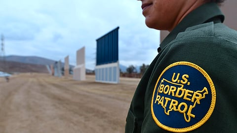 US Border Patrol officer Tekae Michael stands near prototypes of US President Donald Trump's proposed border wall on November 1, 2017 in San Diego, California.
The concrete and steel structures, erected in a remote area in San Diego, will be tested for 30 to 60 days to determine which design meets the needs to secure the border, US Customs and Border Patrol Protection said in a statement. Authorities said that in considering the mockups -- built by six companies from across the United States -- they will evaluate a number of characteristics including anti-breaching, anti-climbing and anti-digging capabilities. / AFP PHOTO / FREDERIC J. BROWN (Photo credit should read FREDERIC J. BROWN/AFP/Getty Images)