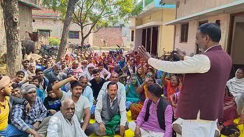 प्रधान के घर पर धरने पर बैठे किसान नारेबाजी करते हुए