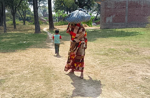 भैंस के लिए खेत से चारा लेकर घर की ओर जाती सुरसती देवी, और साथ में उनकी पोती प्रतिभा