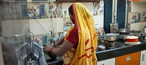 अनीता (45) उर्फ छम्मक एक घर में बर्तन साफ करती हुई