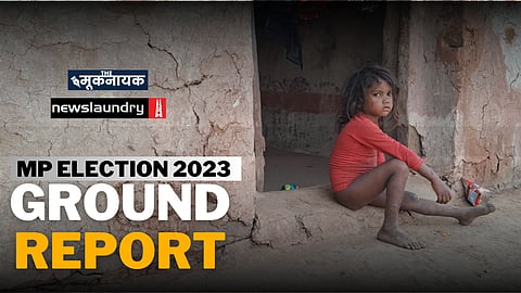 अपने घर की चौखट पर बैठा एक आदिवासी बच्चा