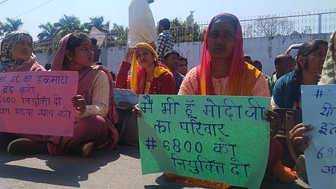 लखनऊ। तख्ती लेकर बैठी महिला अभ्यर्थी.