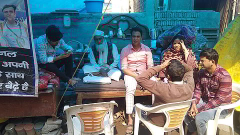 अपने टूटे मकान के बाहर परिवार के साथ बैठे रैट माइनर वकील हसन।