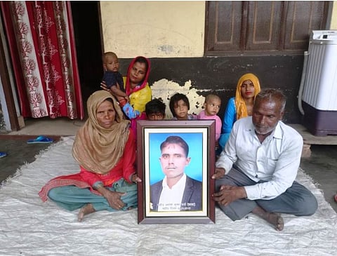 बेटे की फोटो के साथ बैठा परिवार।