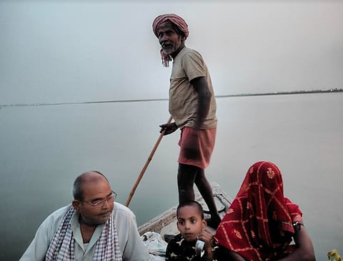 नाव से कोसी नदी पार करते ग्रामीण।