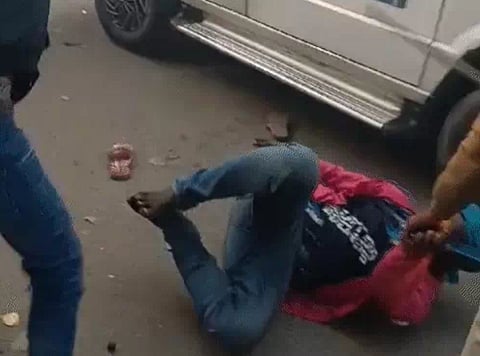 आदिवासी युवक की पिटाई करता पुलिसकर्मी