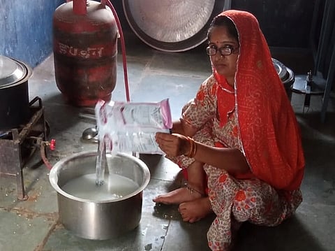 A worker preparing milk for students in a government school in Udaipur