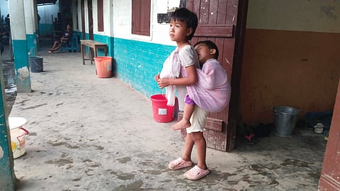A girl carrying her brother on her back at Rengkai Relief Camp in Churachandpur district