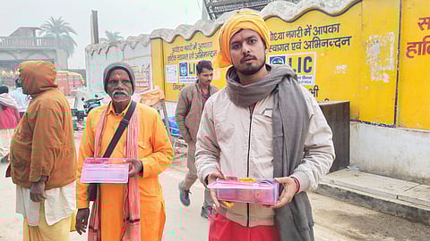 Priests standing outside the temple gate, applying tilak and sandalwood on devotees' foreheads.
