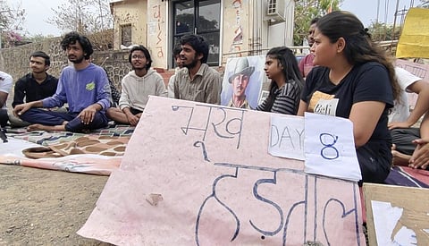 Students stage sit-in protest outside the university gate on Sunday morning.