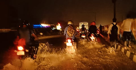 Commuters wading through a water logged road in Delhi