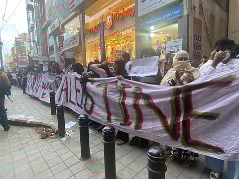 Chain of protestors holding a banner that says "India with Palestine"