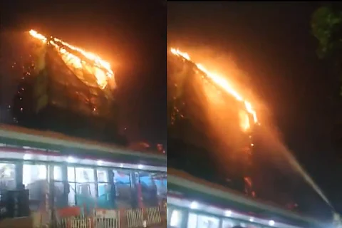 A structure made of straws on fire around the temple's roof.