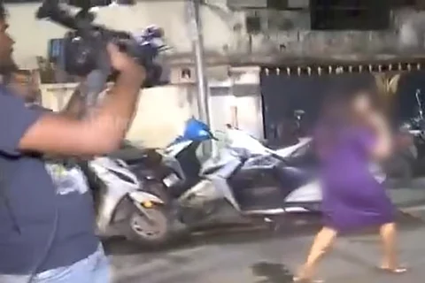 Woman exiting a pub being chased by a cameraman