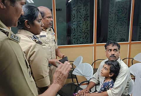 Officers with the Kerala police speak to Abigail Sara and her father