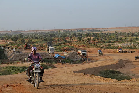 An old man driving a bike on a road at Kaleshwaram project.